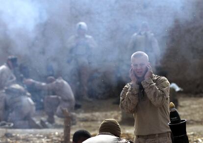 Un 'marine' estadounidense se tapa los oídos antes de que su compañero dispare un mortero contra posiciones de la insurgencia.