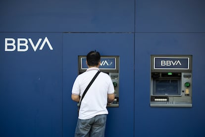 Un hombre saca dinero del cajero en una oficina bancaria del BBVA en Barcelona. 