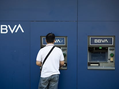 Un hombre saca dinero del cajero en una oficina bancaria del BBVA en Barcelona.
