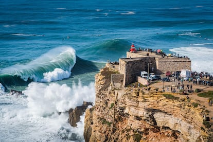 Un grupo de personas contempla las olas gigantes, de hasta 30 metros, desde el faro del puerto portugués de Nazaré, uno de los destinos mundiales más famosos del surf. 