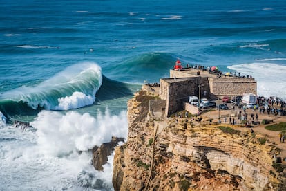 Un grupo de personas contempla las olas gigantes, de hasta 30 metros, desde el faro del puerto portugués de Nazaré, uno de los destinos mundiales más famosos del surf.