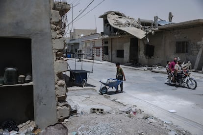 Un niño ayuda en la reconstrucción de una vivienda en Al Qaryatayn, en el este de Siria, el pasado 3 de junio.