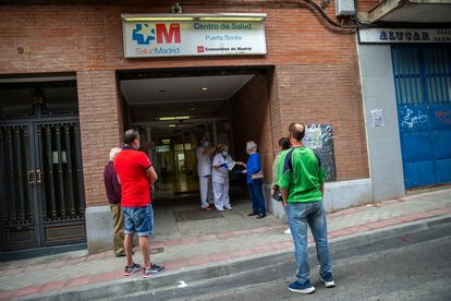 Varios pacientes aguardan ante la puerta del centro de salud Puerta Bonita, en Madrid.