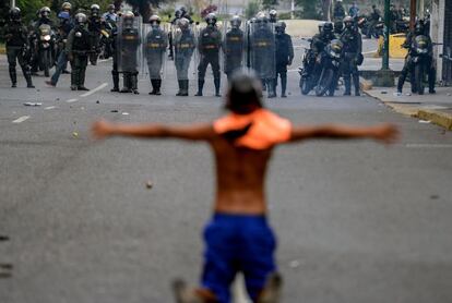 Un activista opositor se enfrenta a la Guardia Nacional Bolivariana durante una protesta contra el presidente venezolano Nicolás Maduro en Caracas (Venezuela).