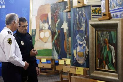 El comisario de la Polic&iacute;a de la Generalitat Valenciana, con camisa blanca, frente a los falsos &#039;picasso&acute; incautados en Granada y Benidorm.