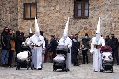 Tres cofrades portan cochecitos de bebé en la procesión de la Estrella que ha tenido lugar este Martes Santo por las calles de Ávila.
