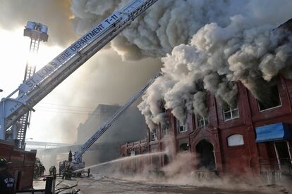 Los bomberos de St. Louis tratan de detener el fuego que se originó en un almacén en St. Louis.