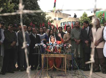 La opositora Benazir Bhutto se dirige a la prensa frente a su domicilio, en Lahore, rodeada de colaboradores.