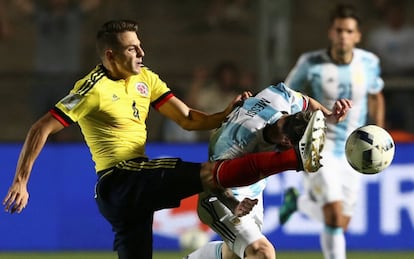 El futbolista colombiano, Santiago Arias, golpea con la pierna a Messi durante una jugada.
