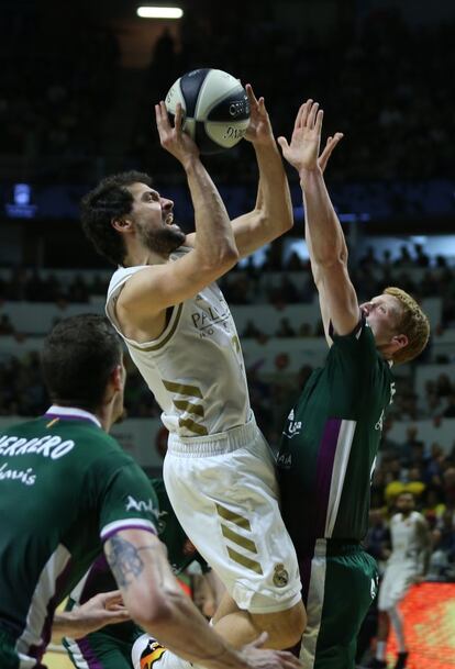 Sergio Llull del Real Madrid, tira a canasta ante la oposición de Díaz del Unicaja.