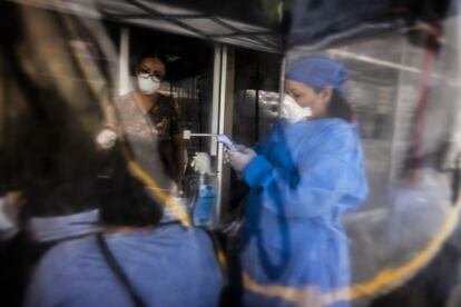 Personal médico toma la temperatura a una paciente en un puesto de control de emergencia instalado en Nuevo Laredo, Tamaulipas.