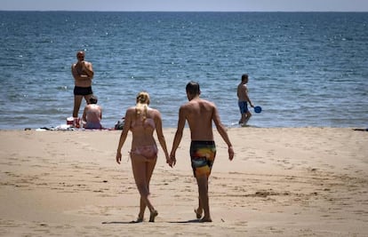 Una pareja camina por la playa, en una imagen de archivo.