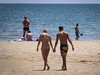 Una pareja camina por la playa, en una imagen de archivo.