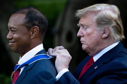 El presidente de los EE UU, Donald Trump, le coloca la Medalla Presidencial de la Libertad al golfista estadounidense Tiger Woods, durante una ceremonia en el Jardín de Rosas de la Casa Blanca en Washington (EE UU), el 6 de mayo de 2019.