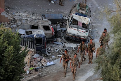 Unos soldados del ejército libanés pasan junto a unos vehículos destruidos en un bombardeo israelí, el sábado en Barja, al sur de Beirut.