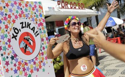 Uma grávida dança ao lado de cartaz contra o zika no Carnaval do Rio.