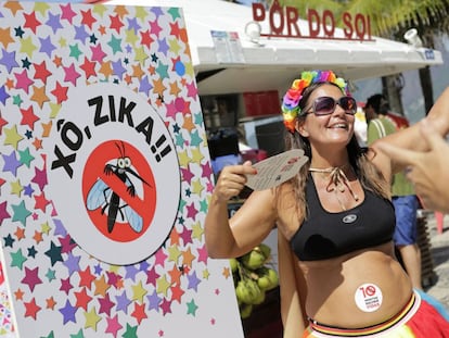 Uma gr&aacute;vida dan&ccedil;a ao lado de cartaz contra o zika no Carnaval do Rio.