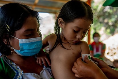María Ana Ramírez (24) sujeta a su hija Yesmin (cuatro años) mientras miden su brazo para descartar síntomas de desnutrición aguda.