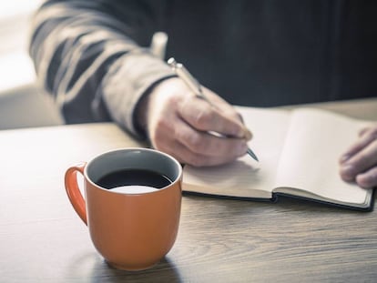 Una persona escribe en un cuaderno.