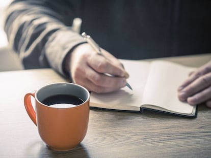 Una persona escribe en un cuaderno.