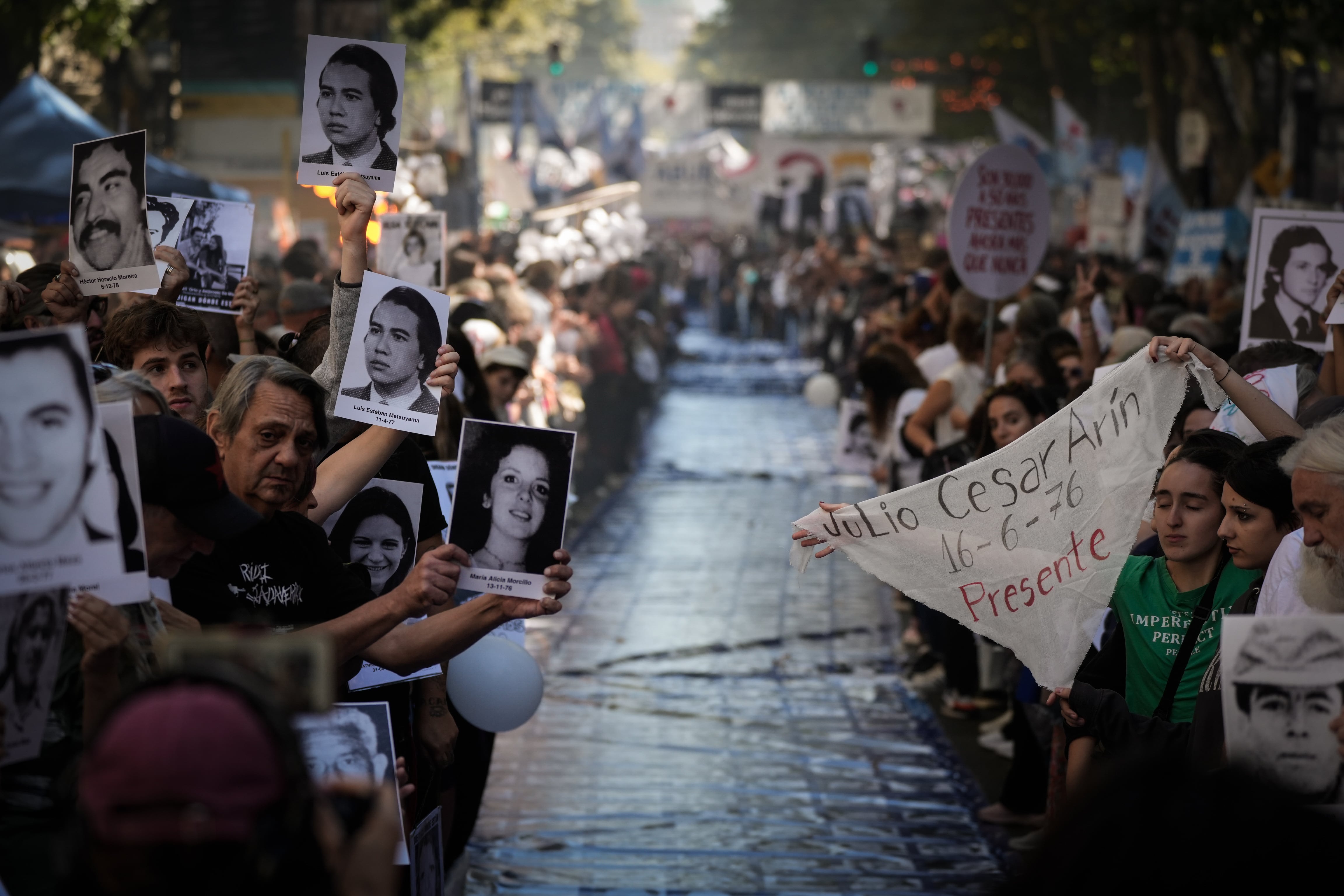 Manifestantes muestran fotografías de los desaparecidos. 