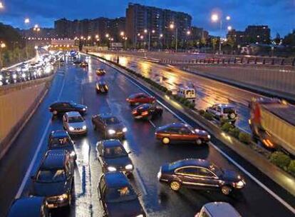 Varios coches cambian de sentido en la avenida de la Ilustración para evitar las balsas de agua en la calzada.