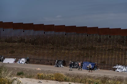 Migrantes resguardados por la Patrulla Fronteriza entre los dos muros que dividen Tijuana (México) y San Diego (EE UU), este jueves.