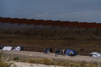 Migrantes resguardados por la Patrulla Fronteriza entre los dos muros que dividen Tijuana (México) y San Diego (EE UU), este jueves.