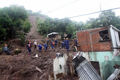 La policía trata de rescatar víctimas de un corrimiento de tierras por las lluvias en Ciudad Arce, El Salvador, ayer.