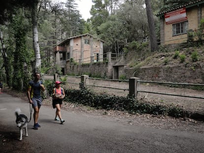 Dos personas pasean con un perro junto al antiguo poblado de Camarasa