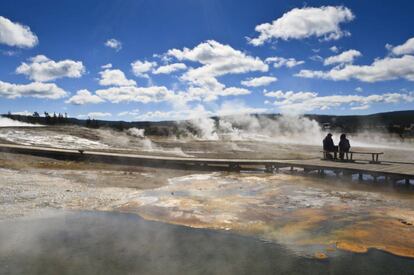 Turistas contemplando Upper Geyser Basin, la mayor densidad de fen&oacute;menos geot&eacute;rmicos del parque de Yellowstone (EE UU)