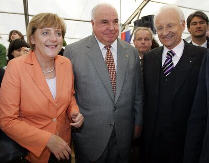 Angela Merkel junto al ex canciller alemán Helmut Kohl y el presidente de la Unión Social Cristiana (CSU) Edmund Stoiber  charla durante una fiesta en la ciudad bávara de Castell cerca de Wuerzburg, el 21 de julio de 2005.