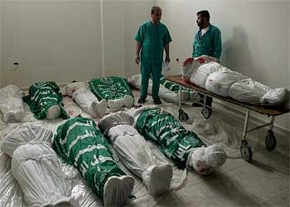 Dos enfermeros, junto a los cadáveres de palestinos muertos en la operación militar israelí de ayer en Rafah, en la franja de Gaza.
/ ASSOCIATED PRESS