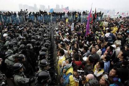 La policía detiene el avance de los manifestantes antiglobalización hacia el Palacio de Exposiciones de Hong Kong.