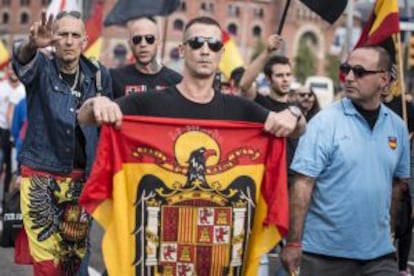 Varios manifestantes portando una bandera con el águila franquista.