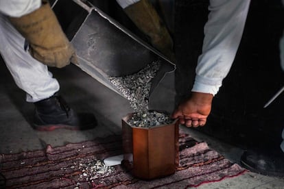 Dos empleados colocan las cenizas de una víctima de covid-19 en una urna, en el crematorio de Iztapalapa (Ciudad de México).