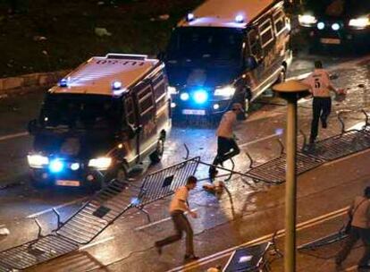 Aficionados madridistas huyen de la policía el domingo por la noche cerca de Cibeles.