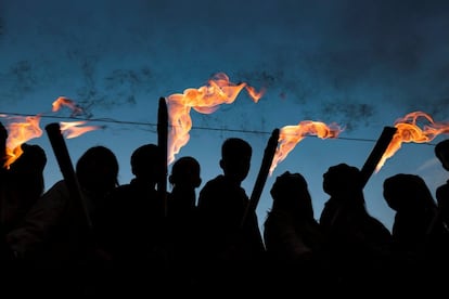 Jóvenes vestidos como en la segunda mitad del siglo XX portan antorchas frente a la Universidad de Tecnología y Economía de Budapest antes de la marcha por las calles de Budapest, el 22 de octubre de 2018. Este acto conmemora el 60 aniversario de las protestas estudiantiles con las que en 1956 se inició la revolución y la guerra por la independencia contra el régimen comunista de la Unión Soviética.