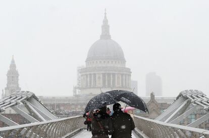 Los peatones caminan sobre el Puente del Milenio mientras cae la nieve sobre Londres (Inglaterra).