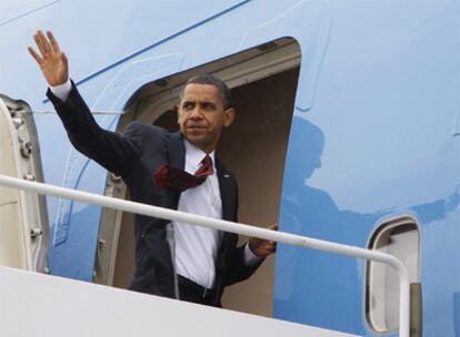 Obama saluda desde el avión presidencial al partir hacia Asia.
