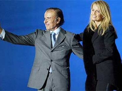 El candidato a presidente de Argentina Carlos Menem, junto a su mujer, Cecilia Bolocco, durante un mítin en Buenos Aires el pasado jueves.