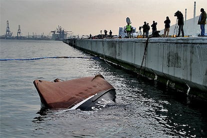 El casco del <i>Nuevo Pilín</i> sobresalía ayer del agua junto al muelle de Santurzi, tras voltearse de nuevo.