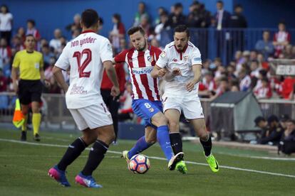 El centrocampista del Atlético de Madrid Saúl Ñíguez disputa un balón con el jugador del Sevilla Pablo Sarabia.