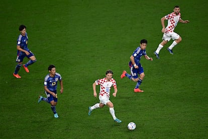 Luka Modric, perseguido por varios jugadores japoneses durante el partido de octavos de final de hoy.  