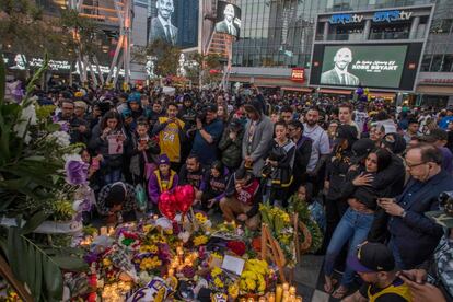 Una multitud de personas se reúne alrededor de un monumento al exjugador de Los Lakers Kobe Bryant, en la plaza LA Live en Los Ángeles (EE UU).