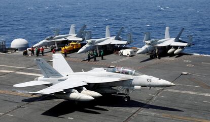 Personal de la armada estadounidense observa el aterrizaje de un caza F18 en la cubierta del portaviones USS Carl Vinson.