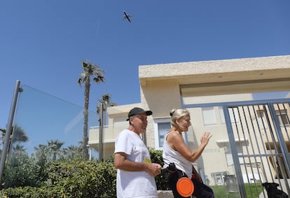 Dos vecinos de Urbanova con un avión al fondo.