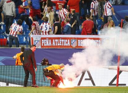 Operarios retiran una bengala en el Atlético-Benfica