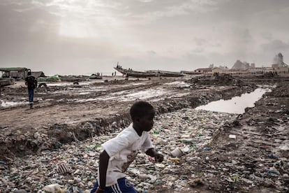Un niño senegalés pasa junto a un gran charco de agua putrefacta en Bargny, julio de 2020.