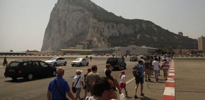 Peatones y coches cruzan ayer hacia el Peñón a través de la pista del aeropuerto.